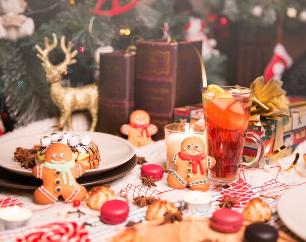 imagem de mesa com bolachas de natal e outros doces de natal com o background de decoração de natal